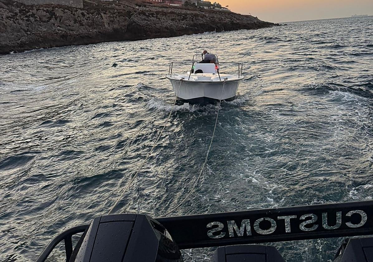 The small boat being towed back to the marina.