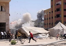 Palestinians flee for cover after an Israeli attack on Jabalia.