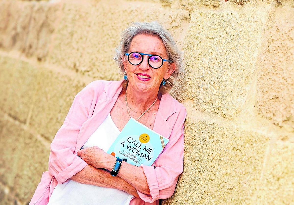 Laurie Levin posing with her book Call Me a Woman about the benefits of gender equality for world peace.