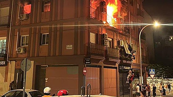 Residents dramatically escape flames in burning building by climbing down façade of apartment block in Malaga