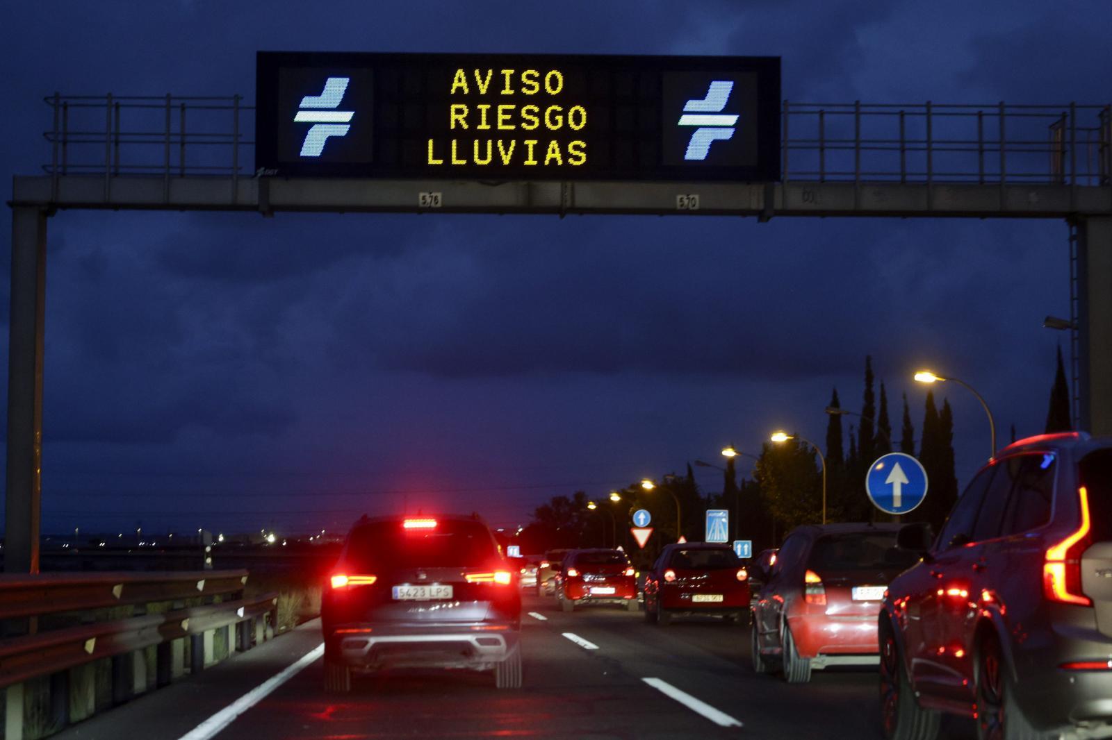 Cars driving along the V30 in Valencia where gantry signs warn of the risk of rain.