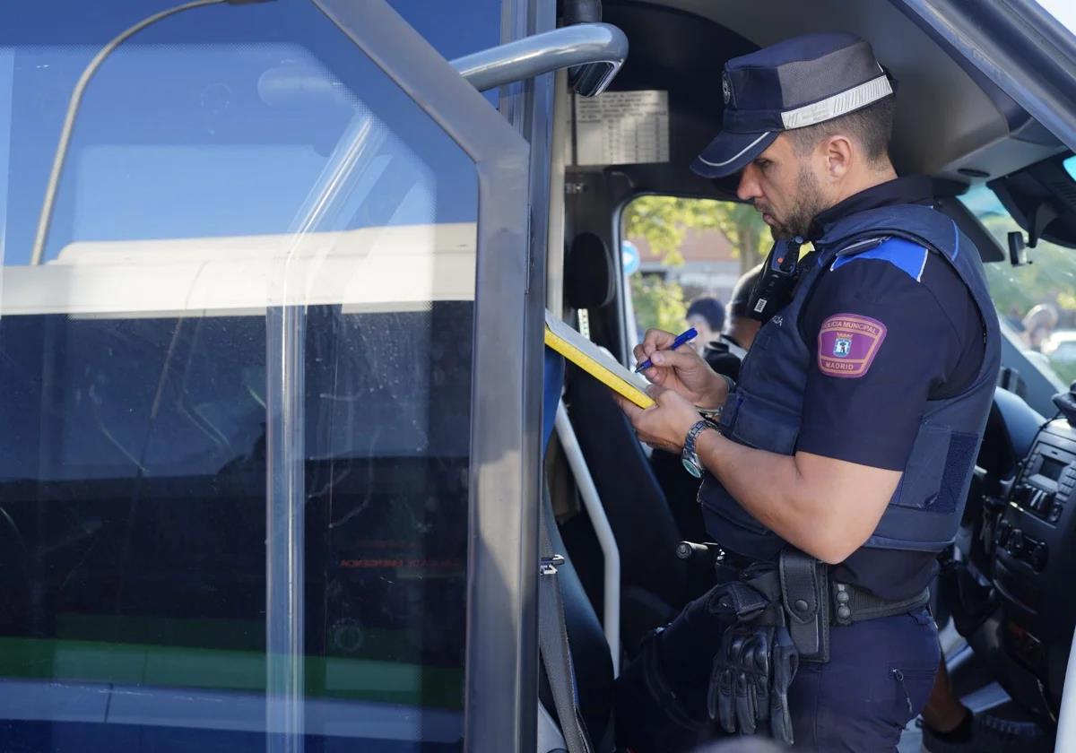 A municipal police officer checks the condition of a school bus.