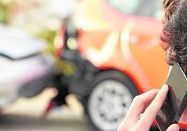 A young man making a phone call following a road traffic accident.