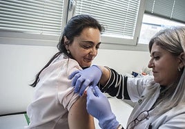 A woman receives a vaccine at a health centre.