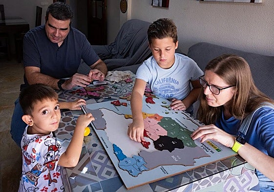Jorge García and Mari Ángeles García do a braille puzzle at home with their two children.