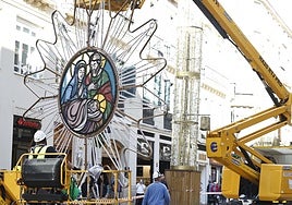 Workers hanging the first illuminated centrepieces on Calle Larios.