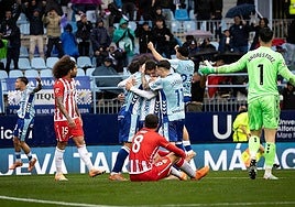 The Malaga players congratulate Dani Lorenzo for scoring the opener.