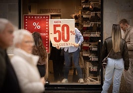 A worker puts up the sale posters in a shop in the city centre.