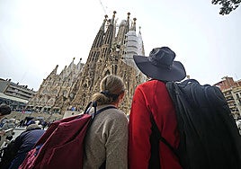 Tourists look at Sagrada Familia in Barcelona.