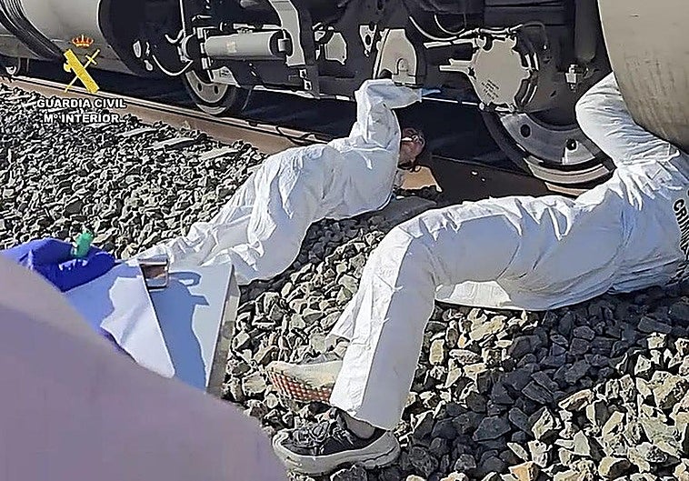 A crime scene officer checks the wheels of the Iryo on Tuesday morning.