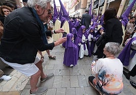 Tourists taking photos of a Semana Santa procession in Malaga.