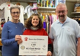 Angela and Alfie Fornear present the cheque to the Save the Children shop in Bath, UK