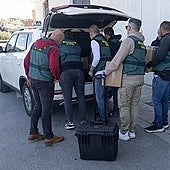 Guardia Civil investigators take boxes with material seized in the search.