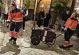 Workers from the municipal cleaning company applying the anti-wax liquid before a procession in Malaga.