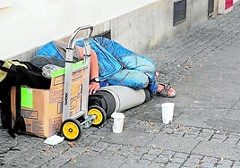 A homeless person sleeping on the street.
