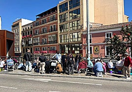 People with folding chairs on the Aurora bridge in Malaga.
