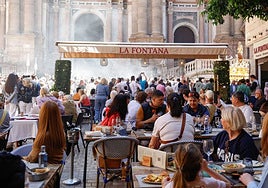 Restaurant customers watching the procession pass in front of Malaga Cathedral on Easter Sunday