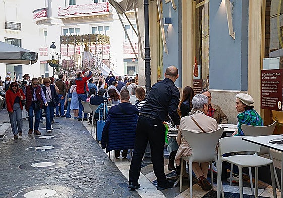 A waiter serving customers at a restaurant in Malaga city centre during Holy Week.