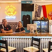 Trish and Tony standing at their Kiwi bar.