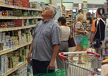 A customer checking products at a supermarket in the town of Gandía.