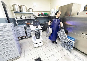 One of the professionals who tends the buffet at the Gran Hotel Luna gives Electra the dirty dishes.