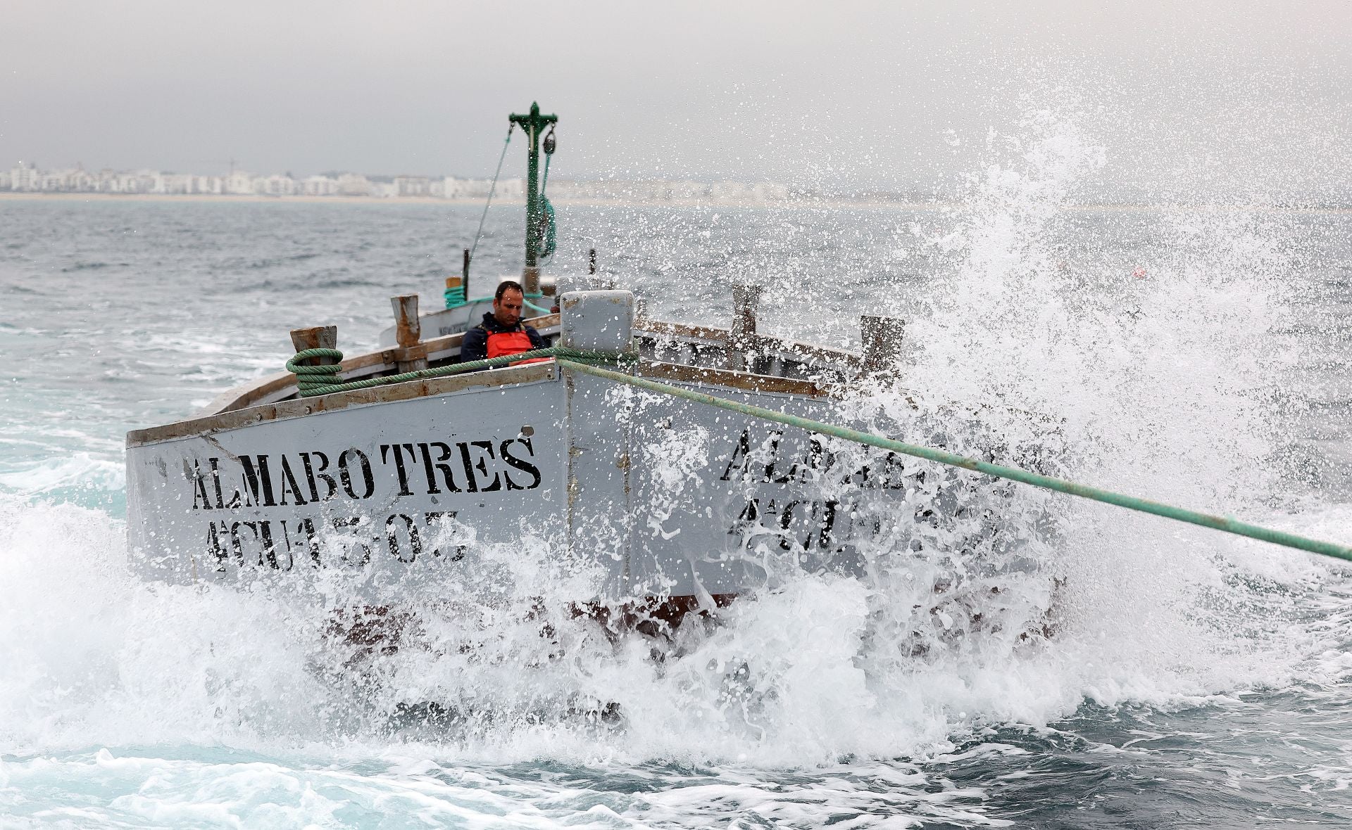 Imagen secundaria 1 - Top, the divers prepare to gauge the fish before directing them to the ‘copo’ net; Below, one of the vessels that forms part of the almadraba fleet and a crew member from the freezer ship used to transport the tuna for sale