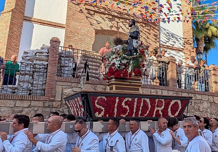 Why do the locals throw wheat at San Isidro in Periana?