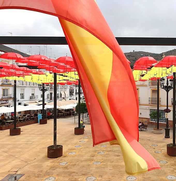 The Spanish flag flies alongside the red and yellow umbrellas