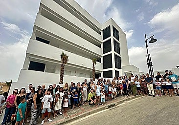 Photo of the families that have received the homes and the authorities responsible for their delivery in front of the building in Fuengirola.