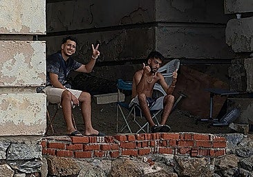 Two Moroccan migrants sheltered under the bridge leading to the moat in Ceuta, beneath the city walls.