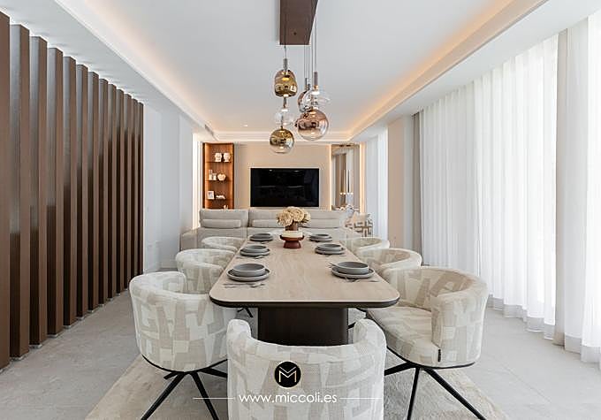 The indoor dining and living area at Santa Clara Marbella uses pale upholstery, timber detailing and pendant lighting.