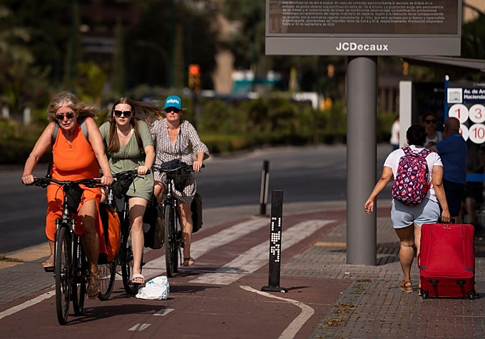 A group of cyclists are cycling through Málaga in the midst of a strong onshore wind.