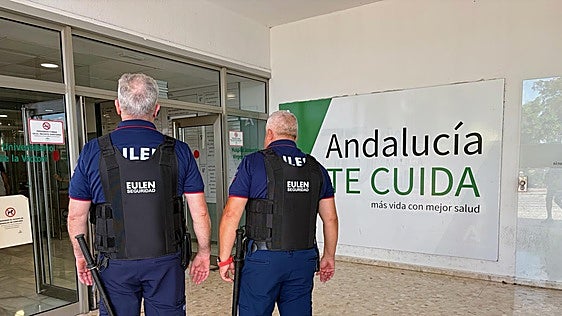 Two security guards at the main entrance to Malaga's Hospital Clínico.