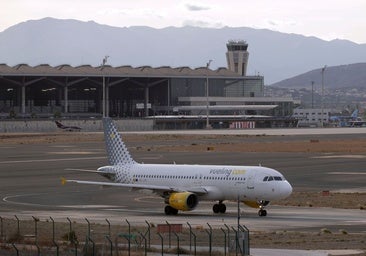 An aeroplane with the Malaga Airport terminal in the background.