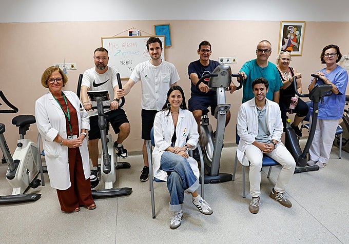 The unit’s team poses alongside three patients on exercise bikes.