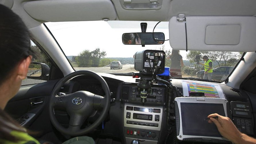 Guardia Civil officers carry out a speed test with mobile speed cameras on a minor road.