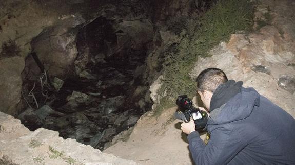 A photographer records the cave where the victims died.