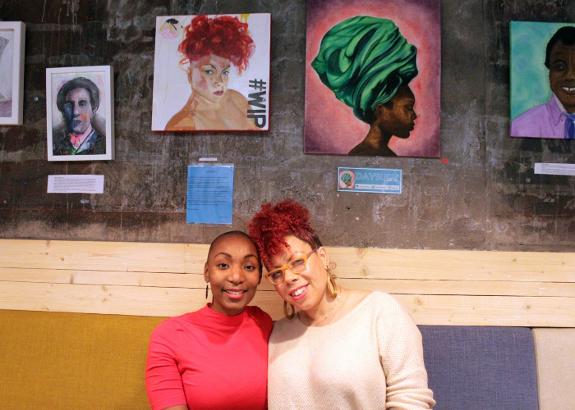 Daysury (left) and Siobhan, pictured underneath their self-portraits in Café de Estraperlo.