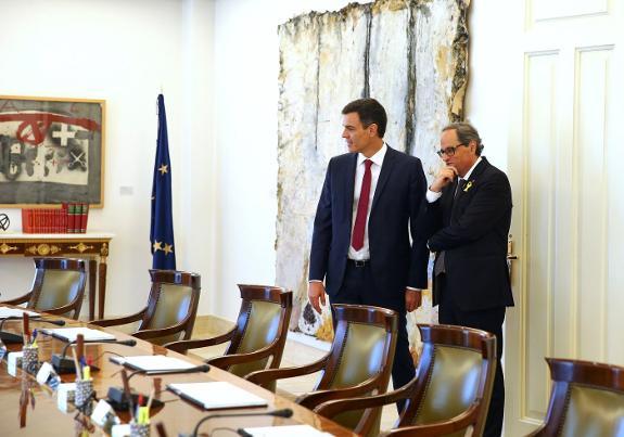 Sánchez (left) shows Quim Torra the Spanish Cabinet room.