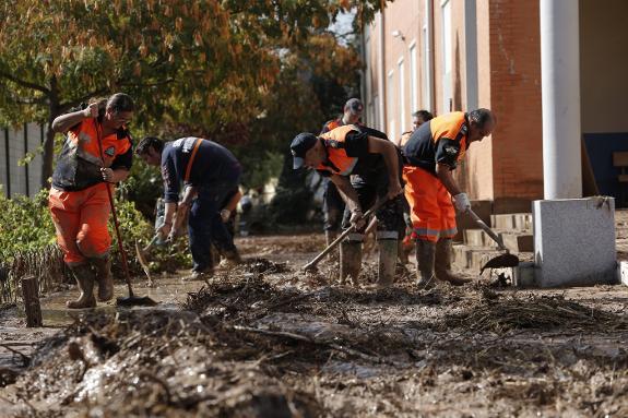 Civil defence workers help the clear-up outside a school in inland Malaga province. 