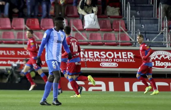 Numancia players celebrate their goal as Malaga's N'Diaye looks on. :: Agencia lof