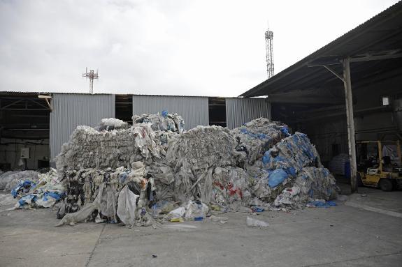 Huge bundles of used  plastic arrive at the factory.