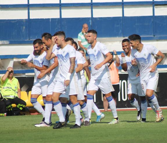 The Marbella players celebrate following a goal.