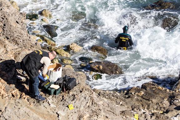 A police diver and officer search for evidence at the scene of a recent crime in Mijas Costa.