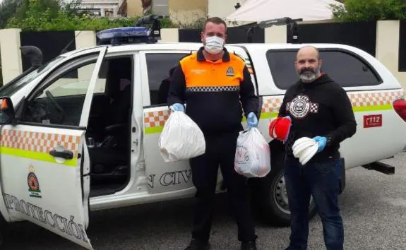 A volunteer in Cártama delivers visors  to a civil protection officer.