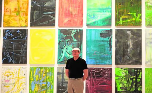 Juan F. Lacomba poses in front of his paintings in the CAC Málaga. 