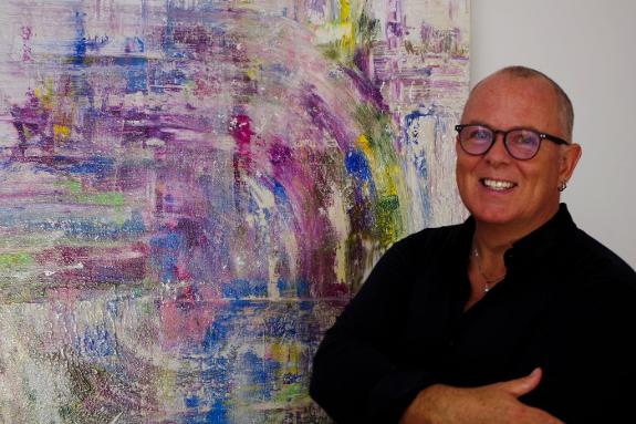 Artist Donald Brennan with one of his colourful abstract pieces, That Summertime Feeling. SUR