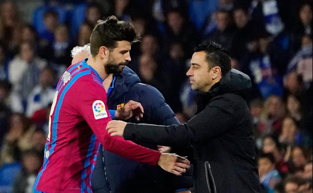 Xavi y Piqué se saludan tras una sustitución esta temporada..