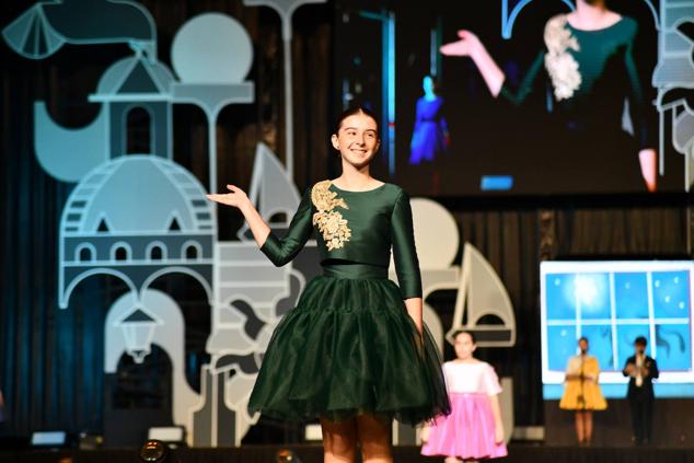 Una de las candidatas infantiles saluda a los foguerers y barraquers durante el desfile individual