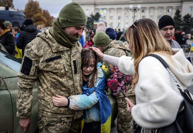 Una niña abraza a un soldado ucraniano mientras los residentes locales celebran la liberación de su ciudad en Kherson, el 13 de noviembre de 2022.